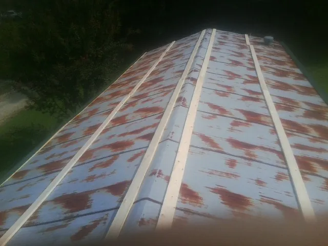 Rusted metal roof panels with new wood purlins before replacement — Storm Damage Roof Repair in Yarmouth by Roofing Brothers