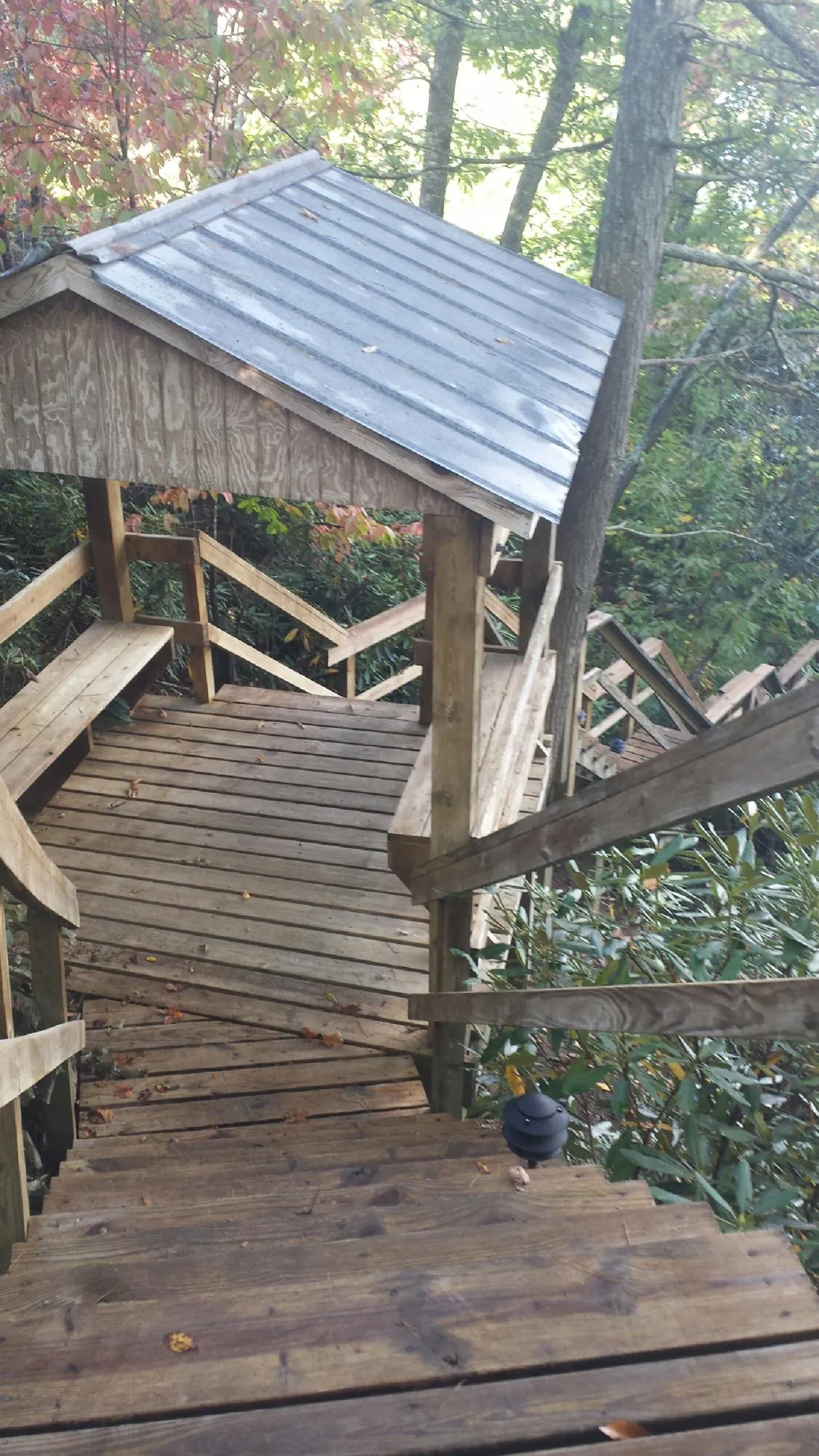 Metal roofed shelter over wooden steps on a wooded walkway — Skylight Repair & Installation work by our crew in Yarmouth