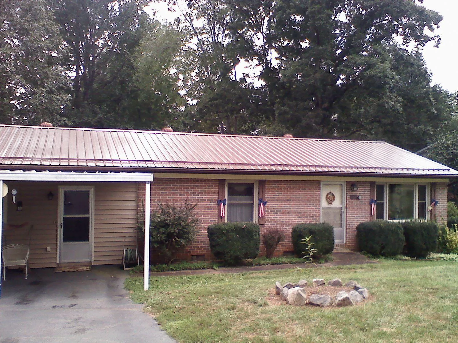 Bronze metal roof and carport on a brick ranch home — Roof Repair work by our crew in Yarmouth